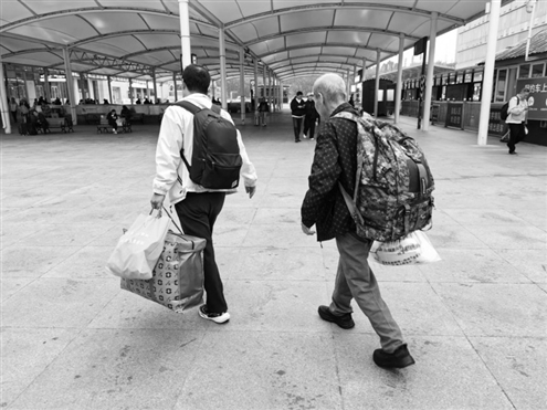 流浪老人在救助中心工作人员护送下回到故乡